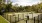 a dog park with a grassy area and trees in the background