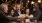 a group of people sitting at a table with food