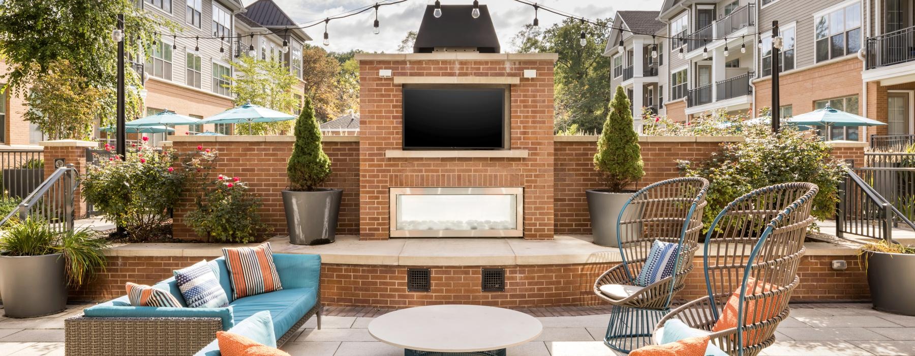 a patio with a fireplace and chairs
